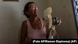 Miriam Cortés posa con su ventilador durante un apagón matutino programado, en su casa de Regla, Cuba, el lunes 1 de agosto de 2022.