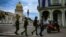 Oficiales de policía caminan cerca del Capitolio, sede de la Asamblea Nacional, en La Habana. (YAMIL LAGE / AFP)