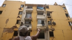 Maru Núñez, de 59 años, señala un edificio de viviendas dañado en la Misión Vivienda en Catia La Mar, Estado de La Guaira, Venezuela, el 12 de julio de 2026. REUTERS/Leonardo Fernández Viloria