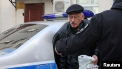 Oleg Orlov, director de la ONG Memorial, es llevado a un interrogatorio en Moscú el 21 de marzo de 2023. (Reuters/Yulia Morozova).