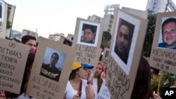 Manifestantes venezolanos en Buenos Aires, con imágenes de víctimas que murieron en las protestas contra el gobierno de Nicolás Maduro el 18 de marzo de 2014. (AP Photo/Esteban Felix, File)