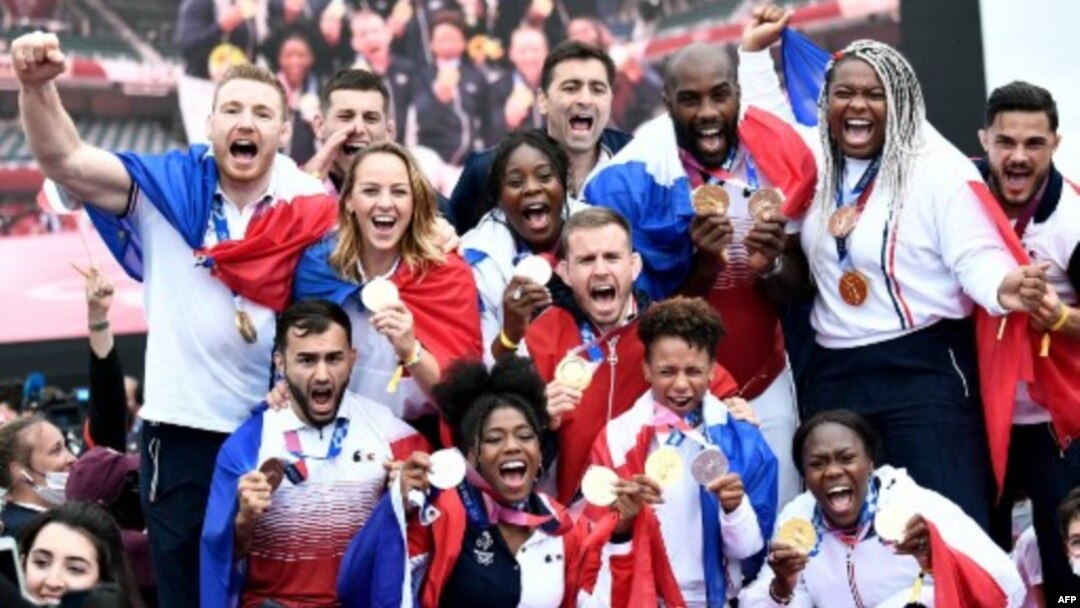 El equipo olímpico de judo francés, medallistas de oro por equipos mixtos, posan mientras celebran su regreso de los Juegos Olímpicos de Tokio 2020 frente a la Torre Eiffel, en París el 2 de agosto de 2021 (Foto de STEPHANE). DE SAKUTIN / AFP)