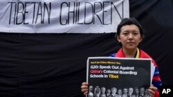 Una mujer tibetana, cubierta con la bandera del Tíbet, protesta en Dharamshala, India, el 9 de septiembre de 2023, en contra de "Los internados coloniales de China en Tíbet". El cartel pide al G20 no guardar silencio sobre este tema. (AP/Ashwini Bhatia).