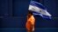 Manifestante enarbola la bandera nicaragüense durante una protesta en Managua. (Archivo)