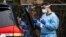 Un trabajador de la salud toma muestras de una persona para un examen de coronavirus, en Riverside Medical Goup, en Secaucus, Nueva Jersey, el 18 de marzo del 2020.