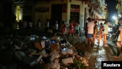 La gente camina junto a montones de basura durante una protesta por los apagones, en La Habana, el 21 de octubre de 2024. REUTERS/Norlys Perez