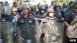 Agentes antimotines de Policía Nacional de Venezuela impiden paso de manifestantes en centro de Caracas.