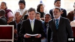 El presidente de Colombia, Juan Manuel Santos (i), recibe el informe "¡Basta ya! Colombia: memorias de guerra y dignidad", de manos del director del Centro Nacional de Memoria Histórica, Gonzalo Sánchez.  