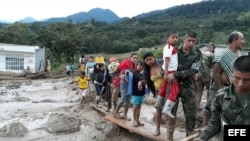 Integrantes del Ejército de Colombia ayudan a pobladores por los estragos ocasionados por el deslave y las inundaciones.