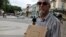 Un hombre anuncia la venta de dos viviendas en un parque de La Habana (Cuba).