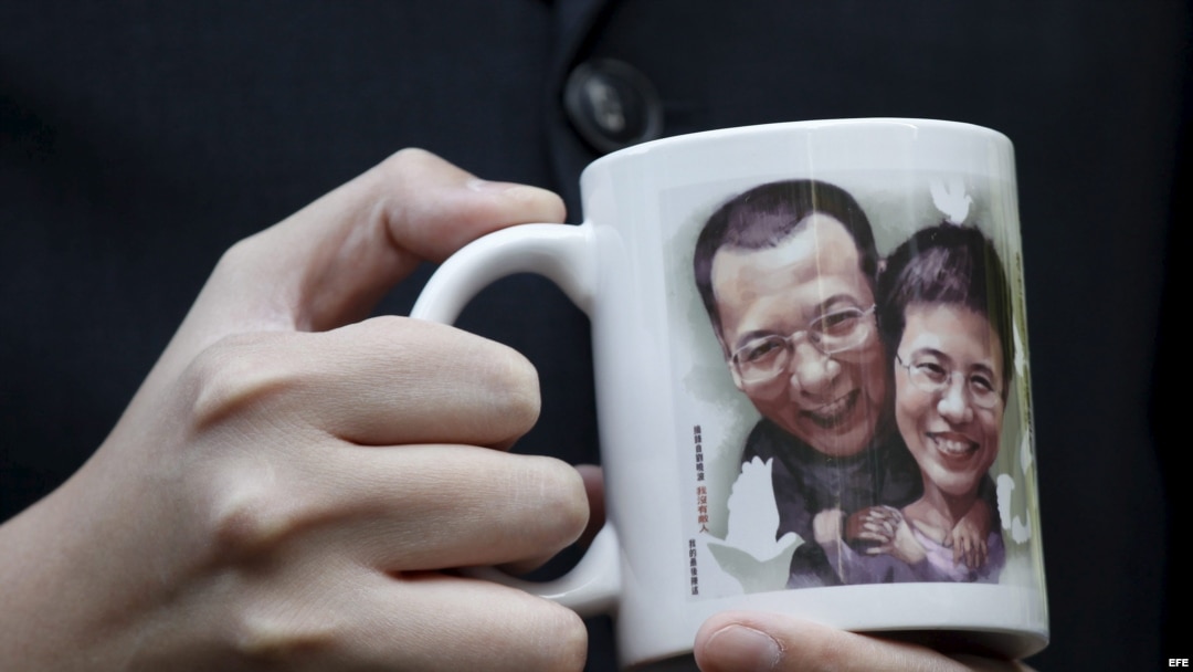 Un activista pro democrático muestra un retrato del disidente chino Liu Xiaobo y de su esposa Liu Xia. 