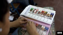 Una mujer prepara papeletas de los candidatos presidenciales en un colegio electoral en Tegucigalpa, Honduras.