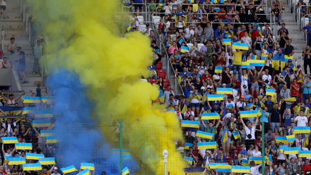 Hinchas de Ucrania vitorean en la grada durante un partido de la Liga de Naciones de la UEFA entre Ucrania y Armenia, en Lodz, Polonia, el sábado 11 de junio de 2022. (AP Foto/Michal Dyjuk)