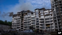 Humo sale de un edificio residencial tras explosiones en Kyiv, Ucrania, este domingo, 26 de junio de 2022. (AP Foto/Nariman El-Mofty)