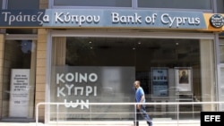  Un hombre pasa delante de una oficina del Banco de Chipre en Nicosia, Chipre.