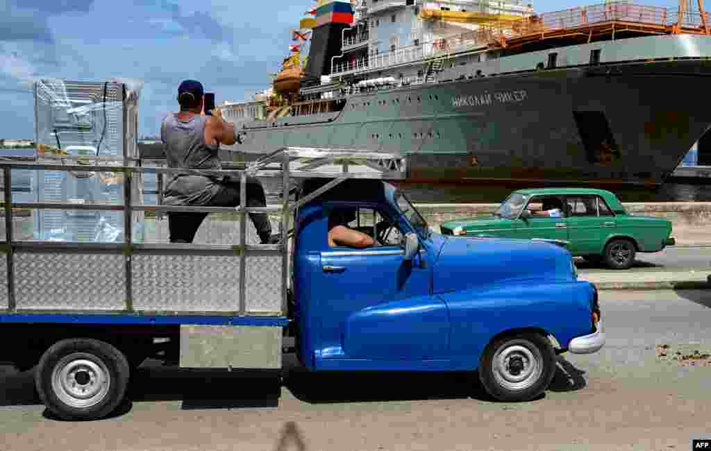 Un hombre toma fotografías del remolcador de rescate y salvamento Nikolai Chiker, parte del destacamento naval ruso que visita Cuba, tras su llegada al puerto de La Habana el 12 de junio de 2024.YAMIL LAGE / AFP