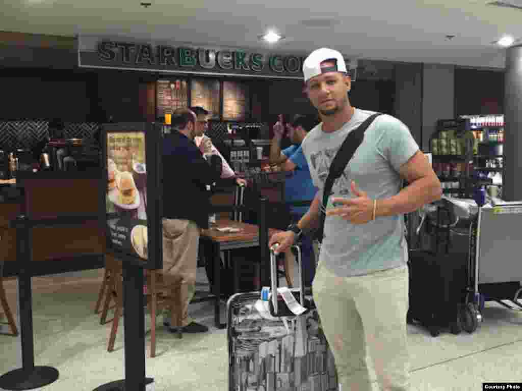 Yulieski Gourriel pasa con su equipaje ante una cafetería Starbucks en el Aeropuerto Internacional de Miami (SwingCompleto)