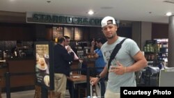 Yulieski Gourriel pasa con su equipaje ante una cafetería Starbucks en el Aeropuerto Internacional de Miami (SwingCompleto)