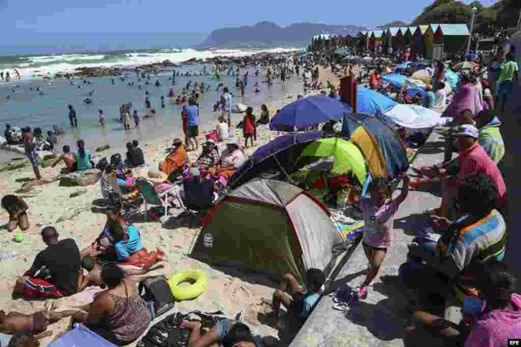 Miles de sudafricanos disfrutan de un día soleado en la playa de St. James con motivo de las tradicionales celebraciones de Año Nuevo en Ciudad del Cabo, Sudáfrica.