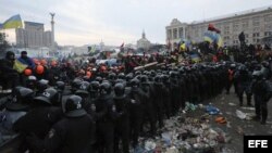 Agentes antidisturbios se enfrentan a los manifestantes durante otro día de protestas en la Plaza de la Independencia de Kiev (Ucrania), hoy, miércoles 11 de diciembre de 2013.