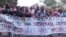 Cubanos caminan con un cartel hacia la frontera.