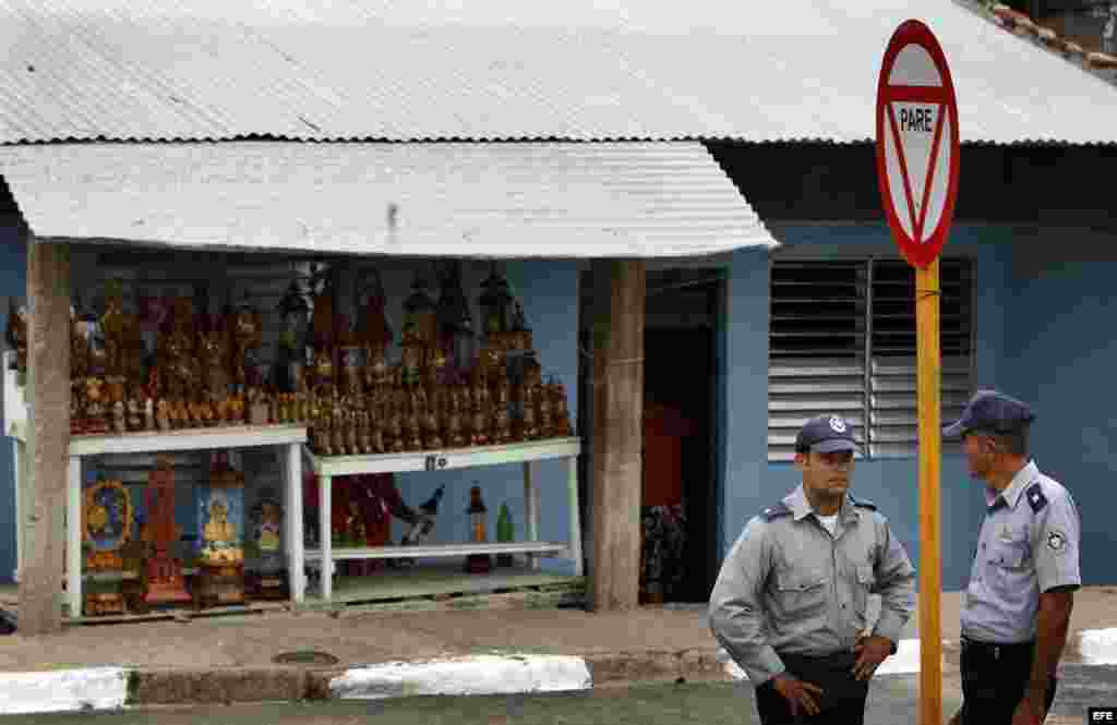 Dos polic&iacute;as vigilan el s&aacute;bado 24 de marzo de 2012 en el poblado El Cobre, Santiago de Cuba, donde se encuentra el santuario de la Virgen de la Caridad 