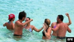 Grupo de turistas bailando en una playa de La Habana (Cuba). 