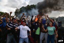 Opositores venezolanos se manifiestan contra Maduro en Caracas.