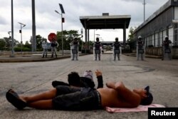 Miembros de la Guardia Nacional vigilan mientras migrantes realizan una protesta bloqueando una carretera en su intento por llegar a la frontera con Estados Unidos, en Huixtla, México 6 de noviembre de 2023. REUTERS/Jose Torres