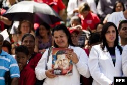 Una enfermera sostiene una imagen del fallecido líder Hugo Chávez hoy, lunes 10 de marzo de 2014, durante el acto de graduación de médicos venezolanos.