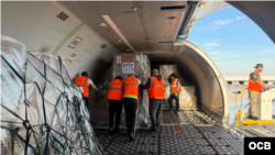 Trabajadores en el Aeropuerto Internacional de Miami aseguran carga de ayuda humanitaria con destino a Venezuela. (OCB)