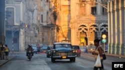 Varios autos circulan por una calle de La Habana Vieja.