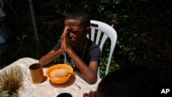 Un niño en Venezuela orando tras recibir una donación de alimentos de una iglesia en Catia, Caracas, Venezuela. (AP Photo/Ariana Cubillos).