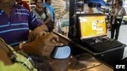 Un grupo de personas se registra en el sistema de compras biometrico para poder adquirir enseres en supermercados en la ciudad de Maracaibo (Venezuela).