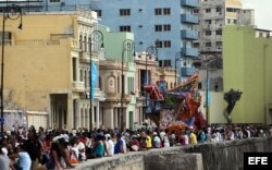 Personas caminan por el Malecón en la exposición "Detrás del Muro" como parte de la XII Bienal de Arte de La Habana.