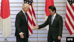 El primer ministro japonés, Shinzo Abe (d), tiende la mano al vicepresidente de Estados Unidos, Joe Biden, durante una reunión diplomática en Tokio (Japón).  