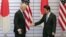 El primer ministro japonés, Shinzo Abe (d), tiende la mano al vicepresidente de Estados Unidos, Joe Biden, durante una reunión diplomática en Tokio (Japón).  