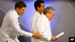 En esta fotografía del 6 de noviembre de 2015, Raúl Guillermo Rodríguez Castro (izquierda), asiste a su abuelo Raúl Castro, junto al entonces presidente mexicano, Enrique Peña, tras ofrecer una conferencia de prensa en Mérida.