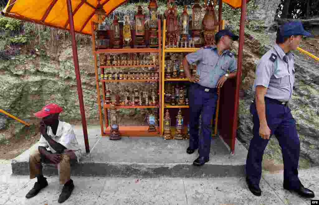 Dos policías observan desde una caseta artesanal el sábado 24 de marzo de 2012, en el poblado El Cobre, Santiago de Cuba