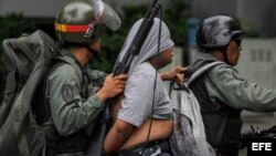 Miembros de la uardia Nacional Bolivariana conducen a un manifestante detenido durante las protestas.