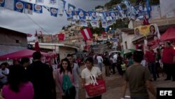 Varias personas caminan en Tegucigalpa (Honduras). Las votaciones generales en el país finalizaron con una masiva afluencia de votantes y sin mayores incidentes. 