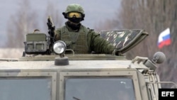 Un militar uniformado armado, fotografiado a bordo de un vehículo de infantería ruso "GAZ Tigr" en el exterior de un cuartel de una unidad del ejércitio ucraniano en la localidad de Perevalnoye, a las afueras de Simferopol, en la península de Crimea.