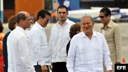 Salvador Sánchez Cerén (d) y su esposa, Margarita Villalta, son recibidos por el vicecanciller cubano Rogelio Sierra (i) a su llegada a La Habana.