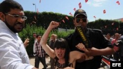  Un agente de seguridad detiene a una de las tres activistas arrestadas frente al Ministerio de Justicia en Túnez (Túnez). 