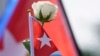 Un manifestante sostiene una bandera cubana y una rosa blanca, símbolo del #15NCuba. (AP/Wilfredo Lee)
