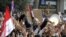 Un manifestante egipcio sostiene una cruz y un ejemplar del Corán durante una protesta organizada por la oposición en contra de Mohamed Mursi, en la céntrica plaza Tahrir de El Cairo, Egipto.