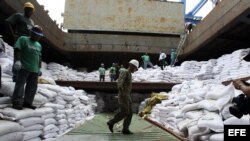 Un grupo de trabajadores desvela varios contenedores ocultos entre sacos de azúcar y que presumiblemente contienen material bélico, dentro del barco norcoreano Chong Chon Gang hoy, martes 16 de julio de 2013, en el muelle de Manzanillo en Colón (Panamá). 