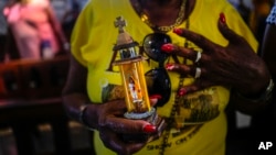 Una religiosa en el Santuario de El Cobre, en Santiago de Cuba, sostiene una estatuilla de la Virgen de la Caridad, venerada como la Patrona de Cuba.