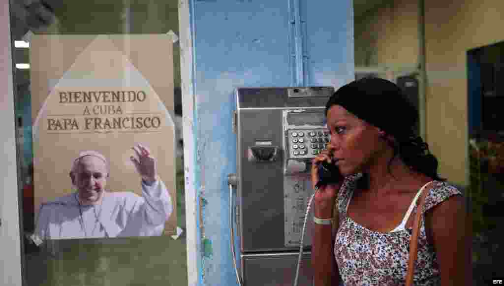 Una mujer habla por teléfono junto a un cartel con la imagen del papa Francisco, en La Habana. EFE