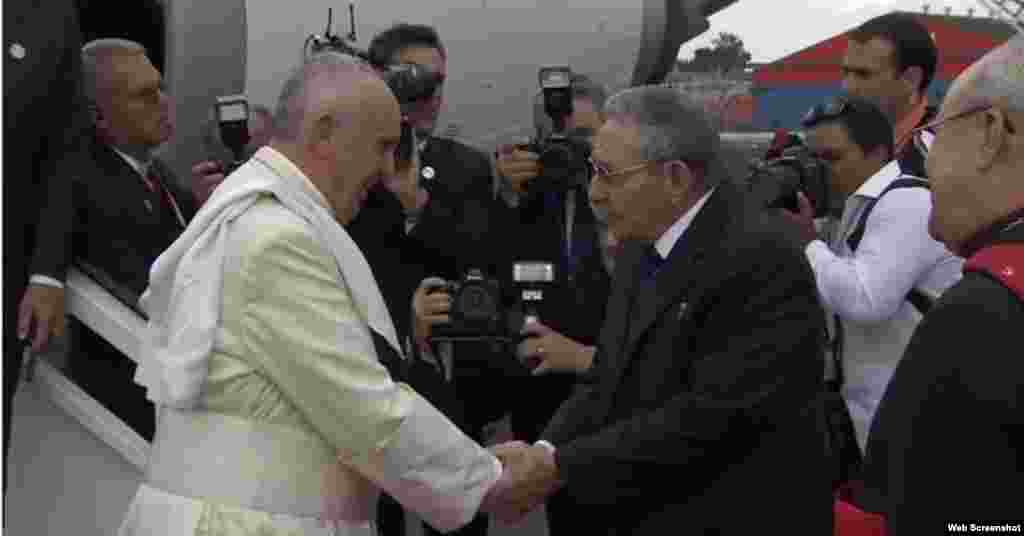 El papa francisco y el gobernante cubano Raúl Castro se estrechan la mano.